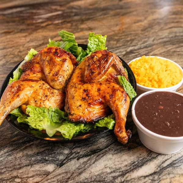 Grilled chicken on lettuce with sides of yellow rice and black beans from 3 Chefs and a Chicken.